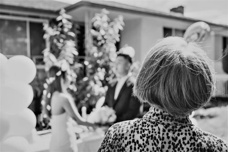 Black-and-white photograph of a guest watching the ceremony