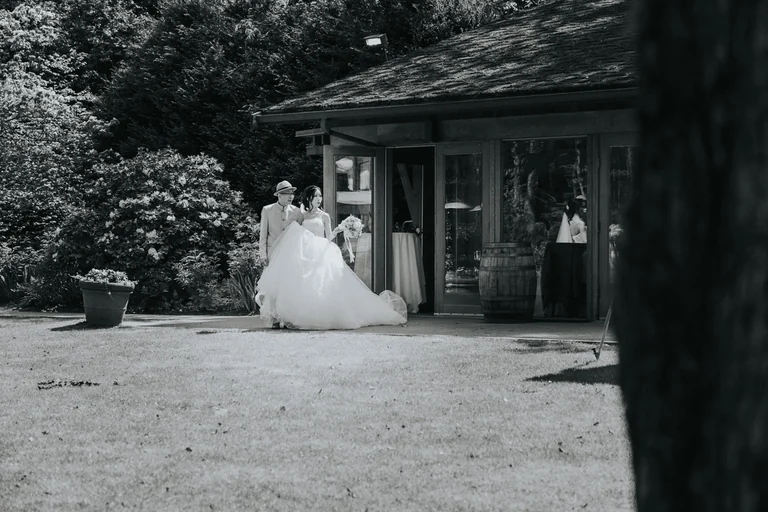 Black-and-white portrait of a bride outside a garden venue
