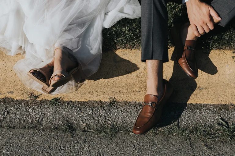 Bridal shoes and the groom's shoes on a stone pathway