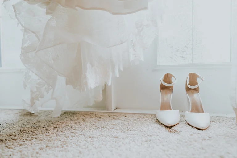 Bridal shoes beside the wedding dress