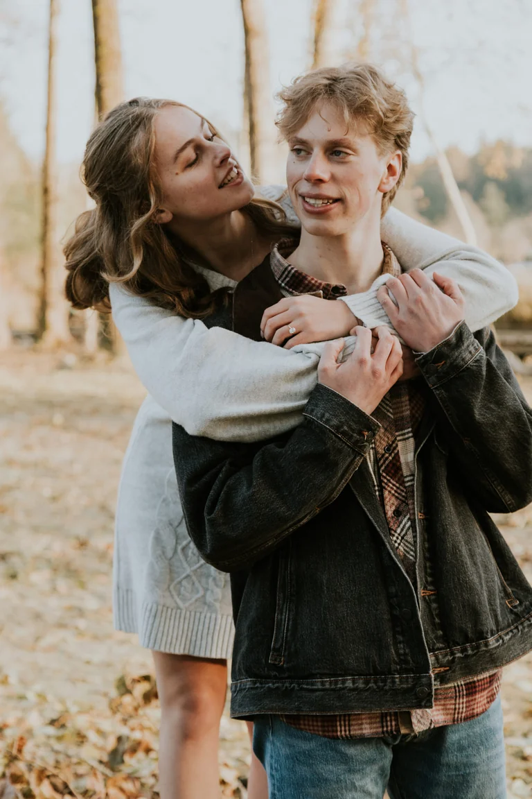 Bride and groom embracing beside a tree