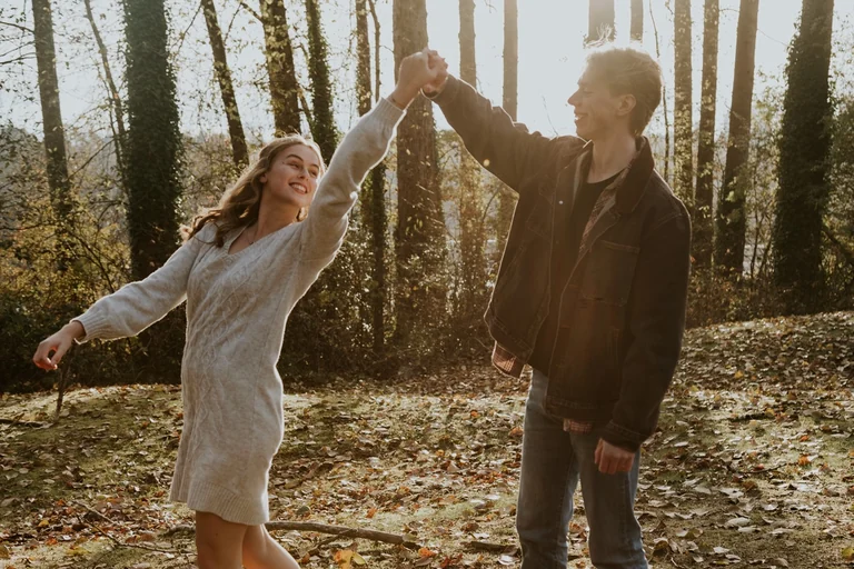 Bride and groom holding hands among tall trees