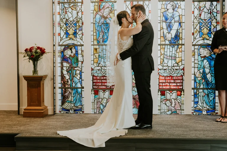 Bride and groom kissing during a church ceremony