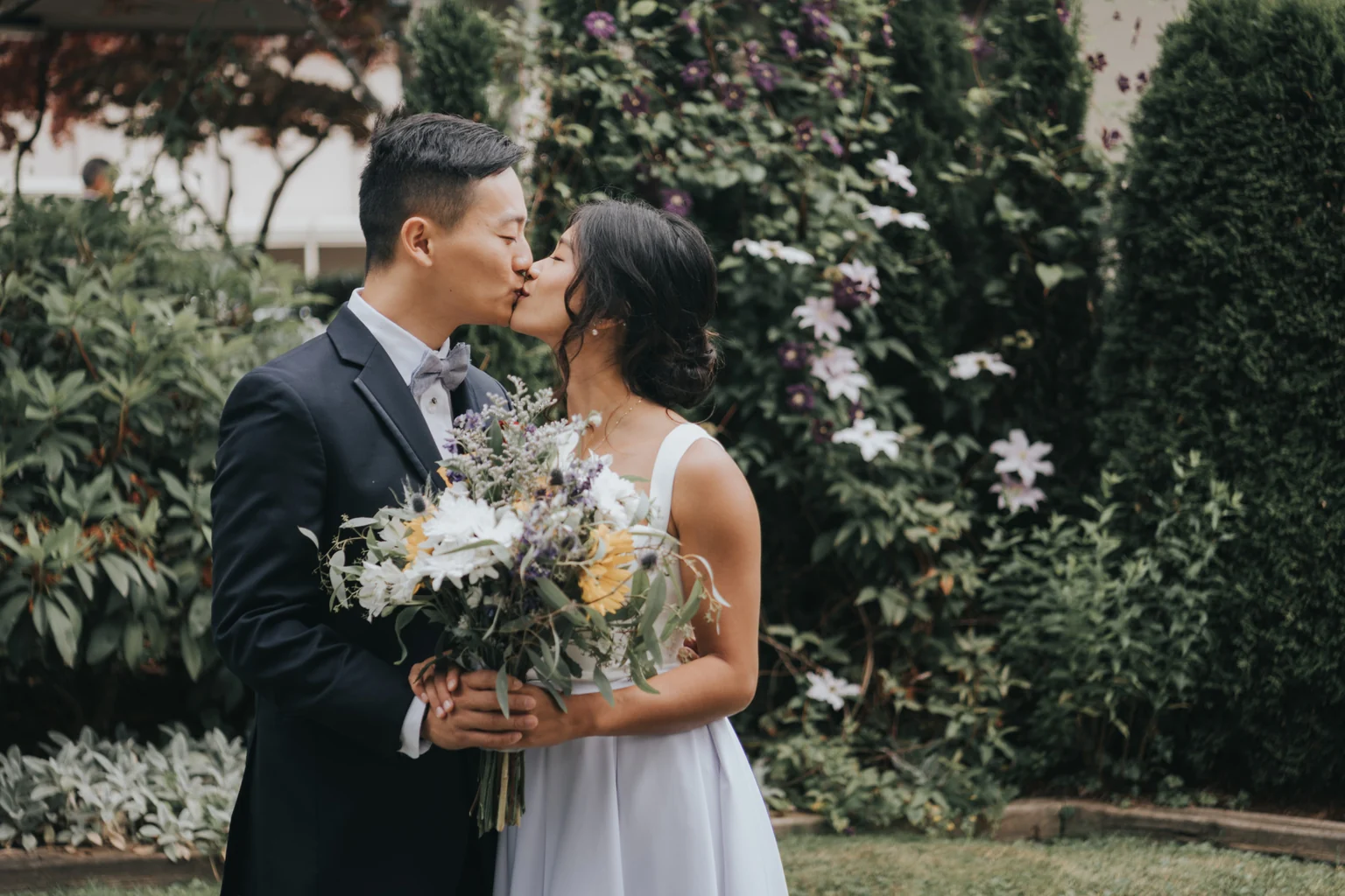 Bride and groom posing together in a garden