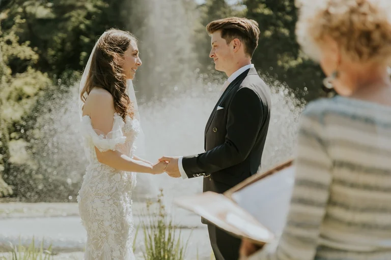 Bride and groom reading vows in a garden