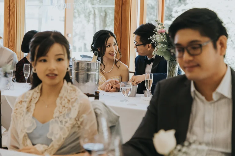 Bride and groom sitting with guests at the reception