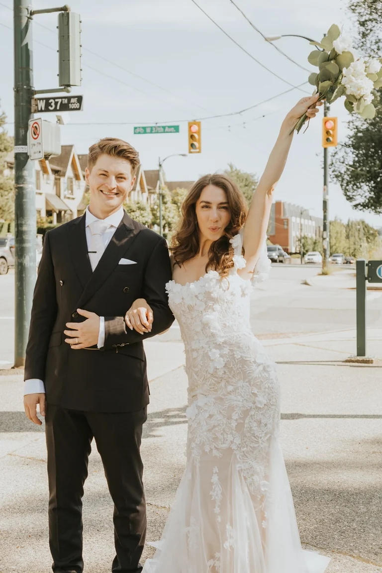Bride and groom standing beneath a wedding arch