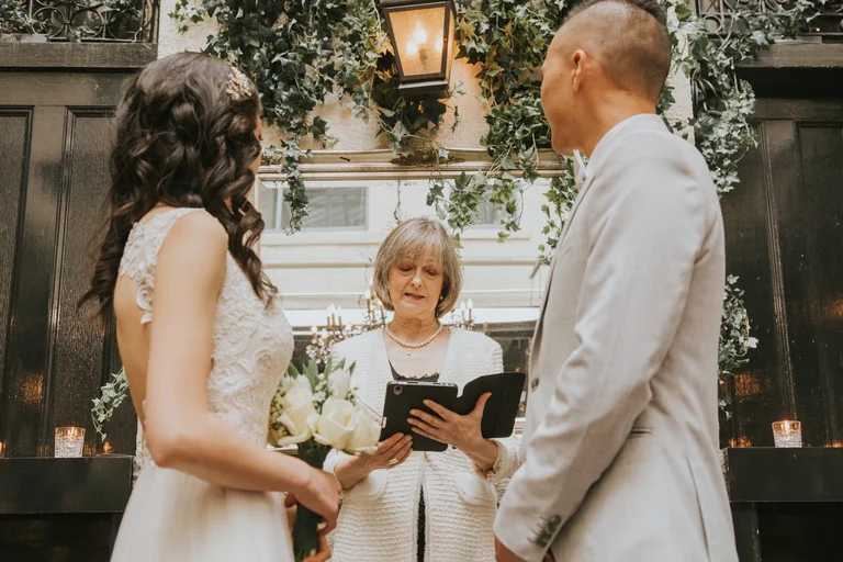 Bride and groom standing with their officiant