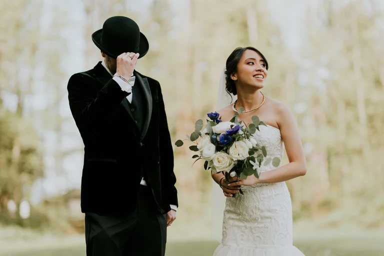 Bride and groom walking together beside flowers