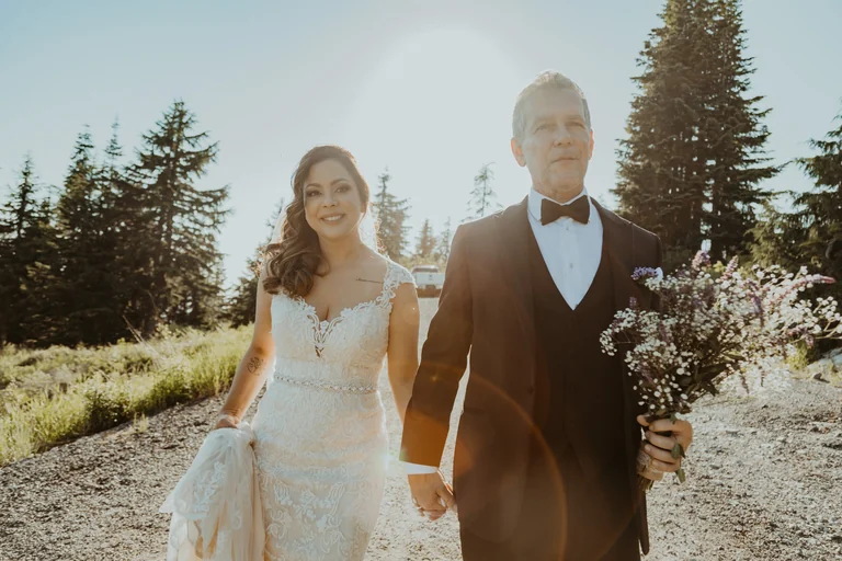 Bride and groom walking together in sunlight