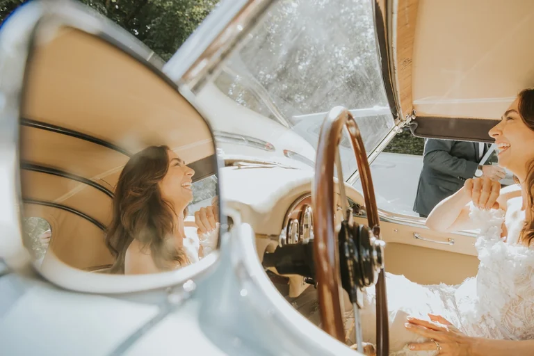 Bride reflected in the window of a wedding car