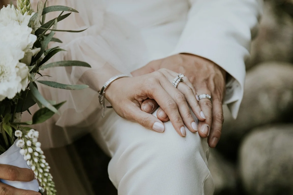 Bride's ring resting on the groom's arm