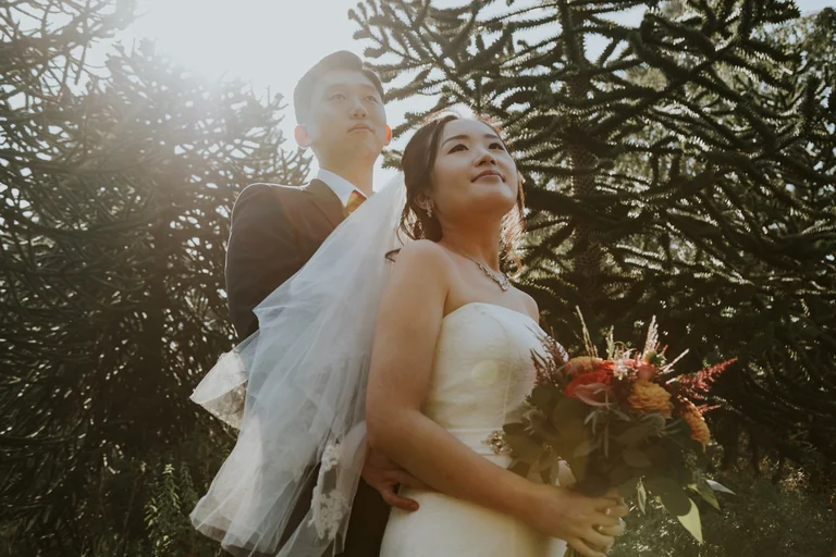 Bride smiling with her bouquet in the sunlight