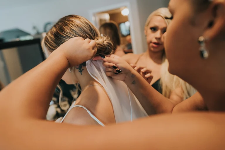 Bridesmaids helping the bride get ready