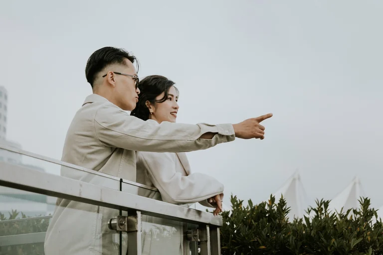 Couple pointing into the distance beside the water