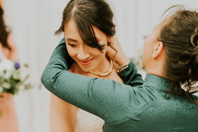 Family member helping the bride with an earring