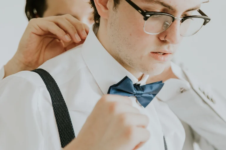 Groom adjusting his collar before the wedding