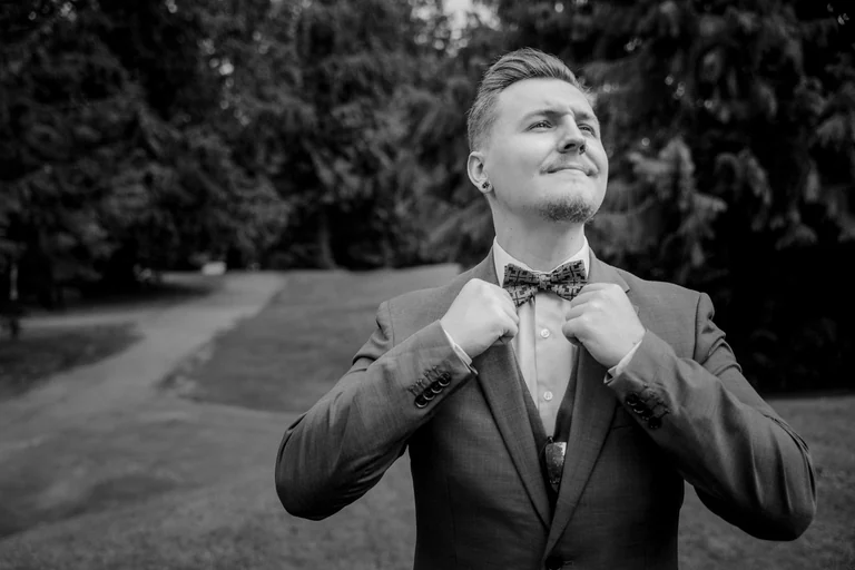 Groom adjusting his tie outdoors