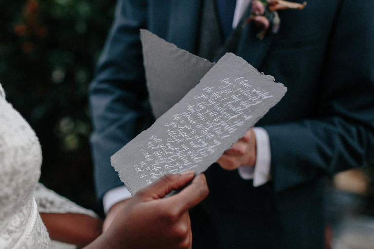 Groom holding a wedding vow booklet