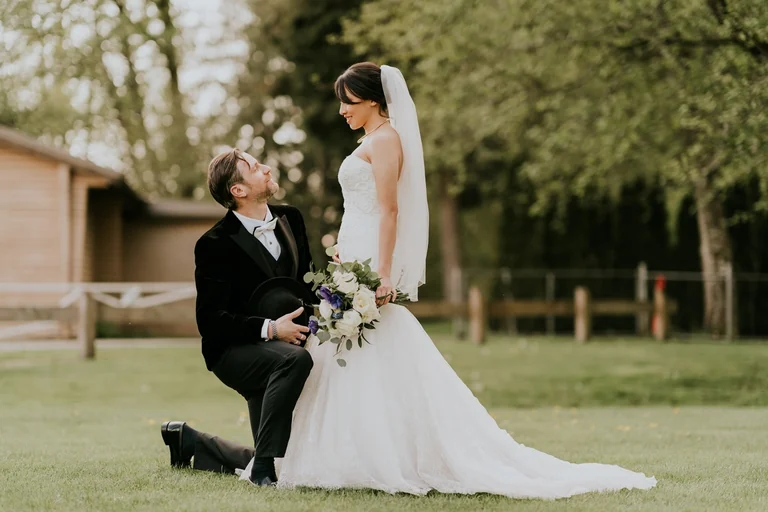 Groom kneeling before the bride outdoors