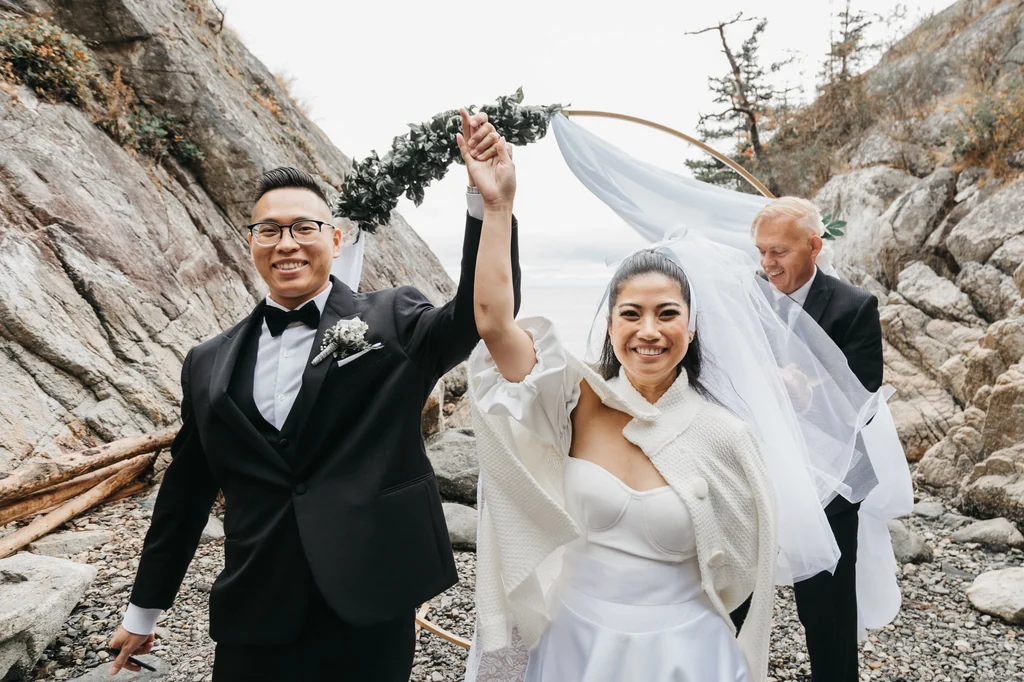 Groom raising his arm beside the bride