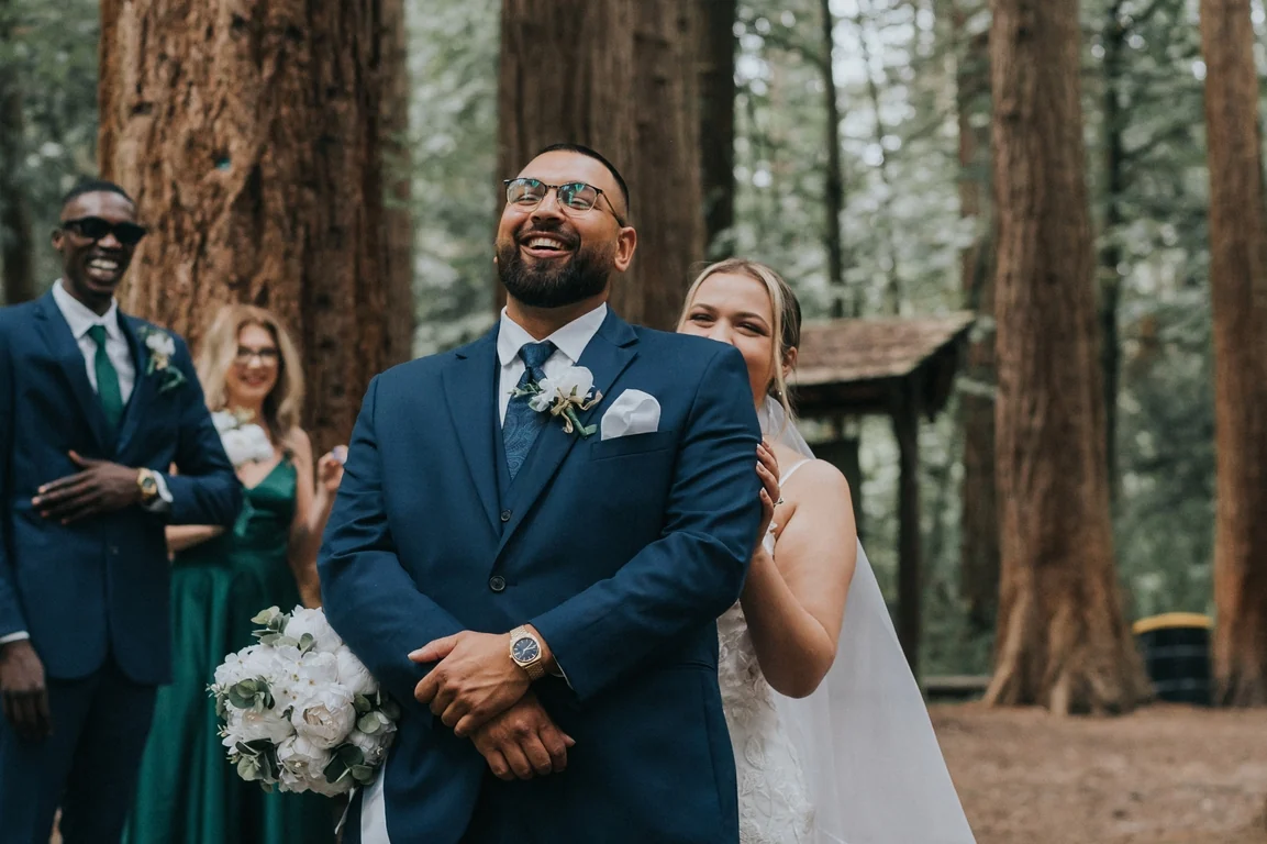 Groom smiling at an outdoor wedding ceremony
