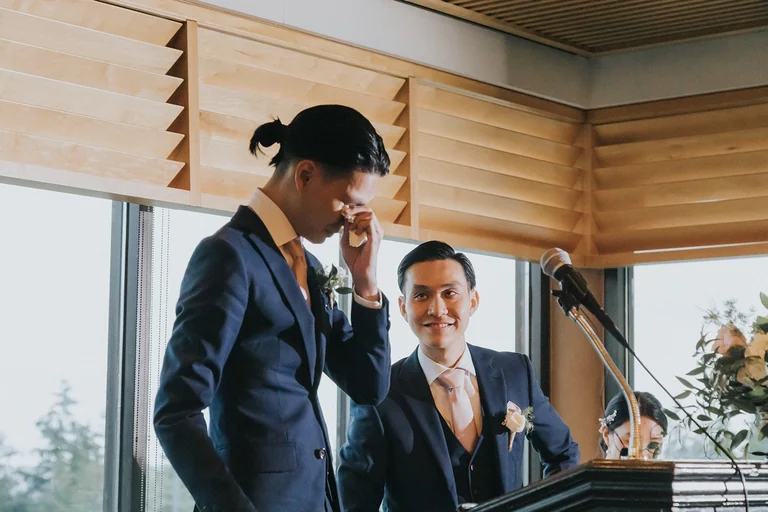 Groom smiling beside the reception piano