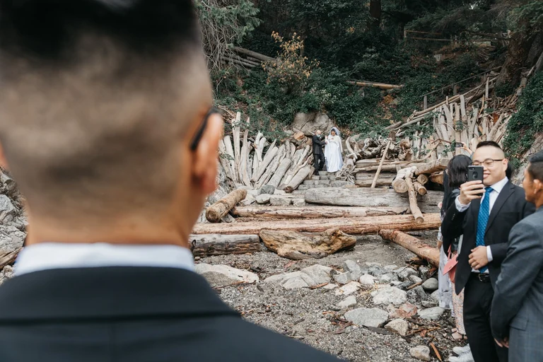 Groom watching the bride at an outdoor ceremony