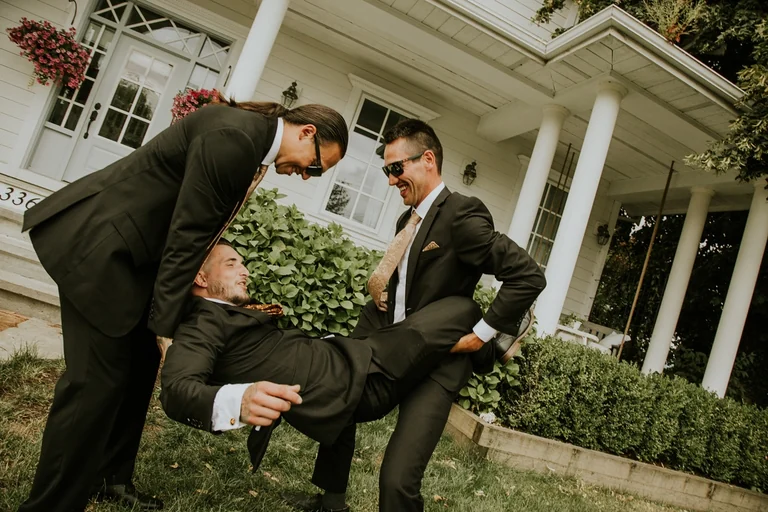 Groomsmen sharing a playful moment before the wedding