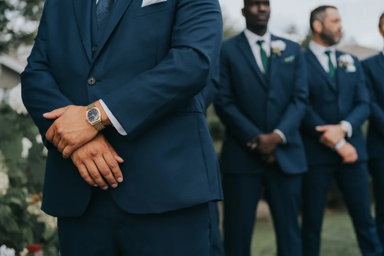 Groomsmen wearing blue suits with white flowers