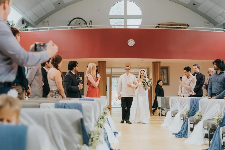 Guests applauding newlyweds after an indoor ceremony