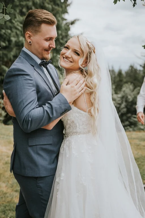 Newlyweds embracing beside a tree