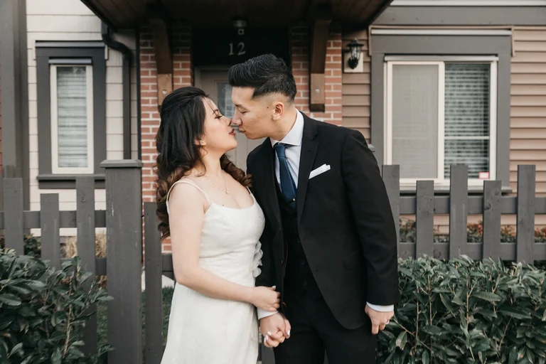 Newlyweds embracing on a front porch