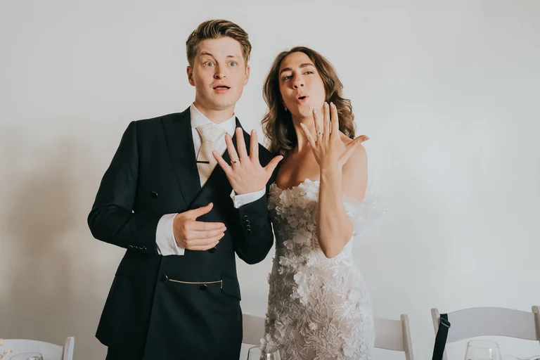 Newlyweds holding up their hands for a portrait