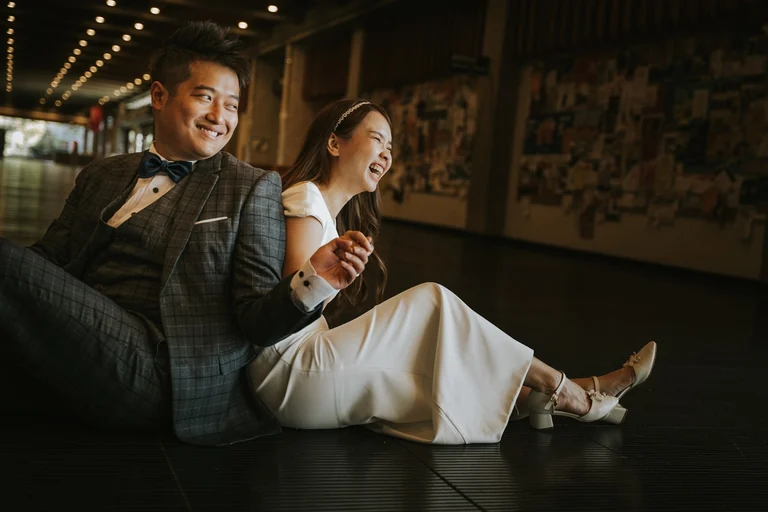 Newlyweds laughing together on a sofa