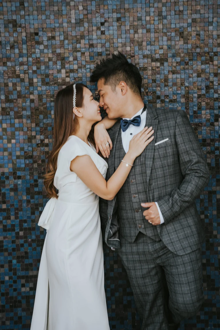 Newlyweds posing against a patterned wall
