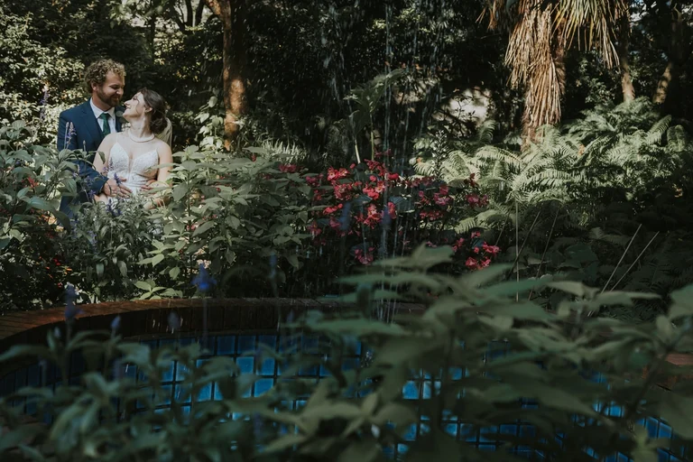 Newlyweds posing among garden plants