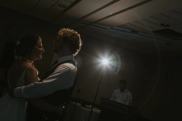Newlyweds sharing a dance beneath a spotlight