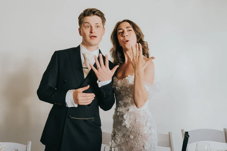 Newlyweds showing their hands during a playful portrait