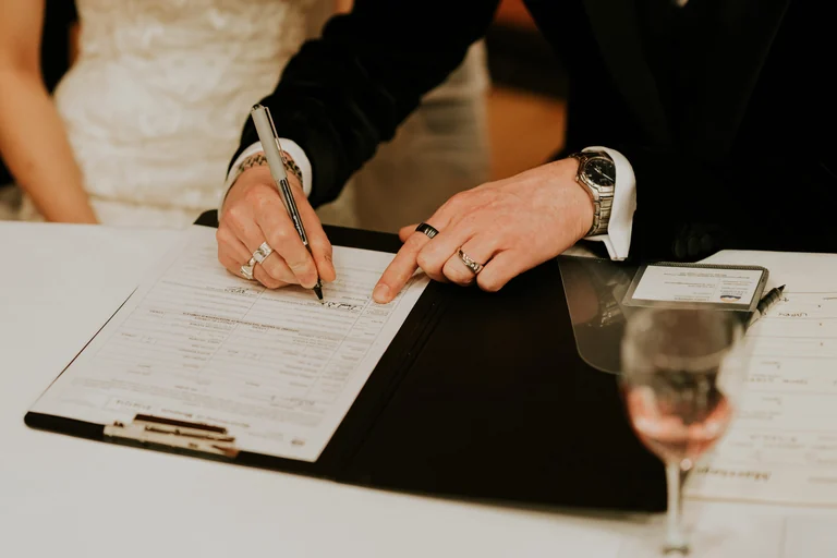 Newlyweds signing a wedding document