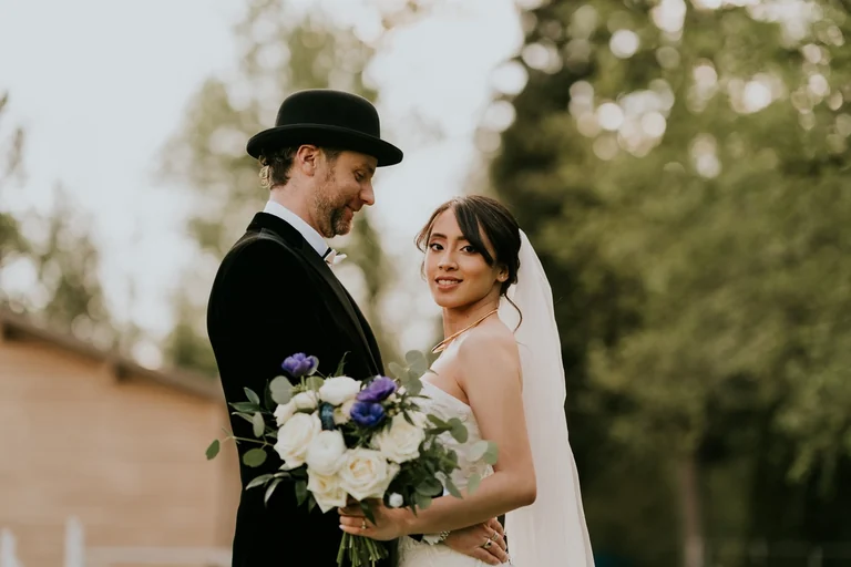 Newlyweds smiling during outdoor wedding portraits