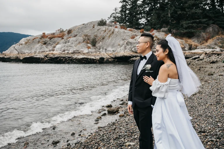 Newlyweds standing together beside the sea