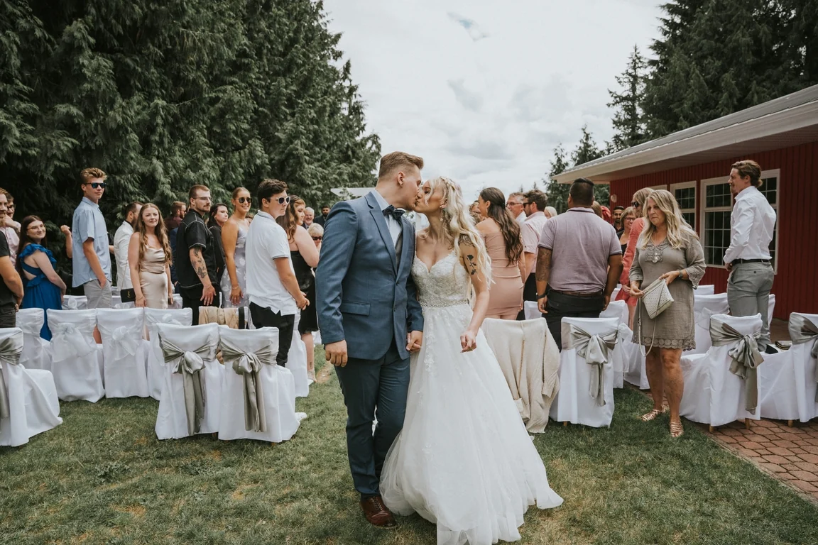 Newlyweds walking down the outdoor ceremony aisle