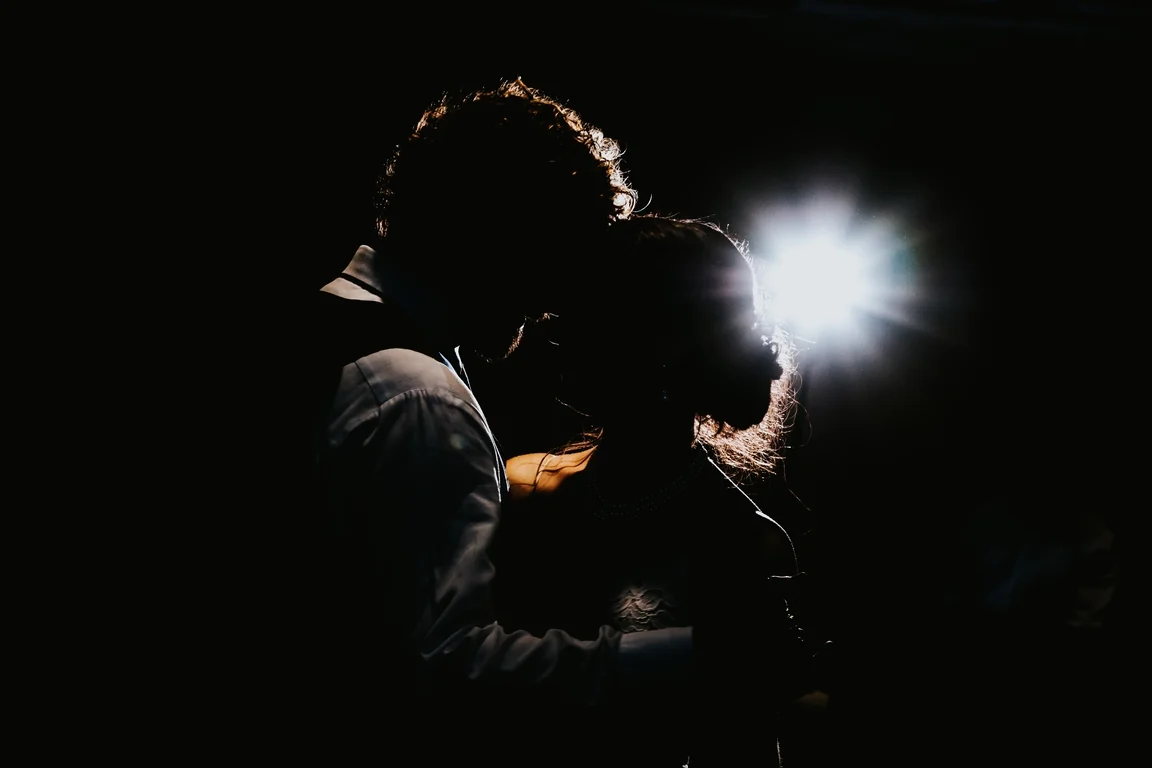 Silhouette of newlyweds dancing in a spotlight