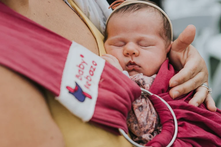 Sleeping baby held by a wedding guest