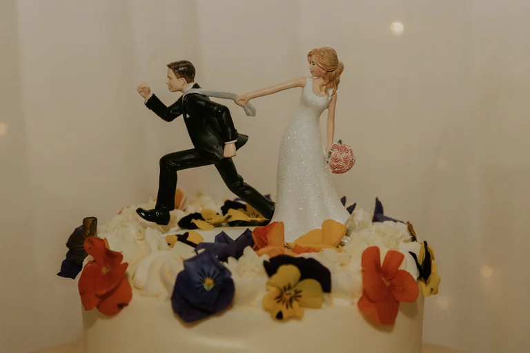 Wedding cake decorated with playful bride and groom figures