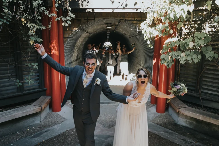 Wedding couple celebrating outside a garden pavilion