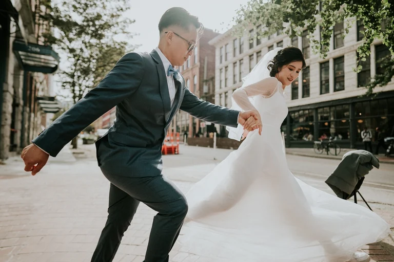 Wedding couple dancing along a city street