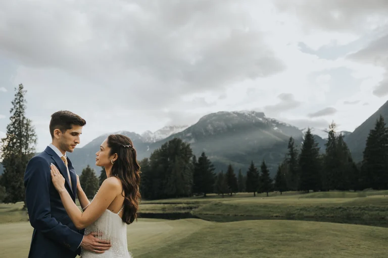 Wedding couple posing beside a mountain landscape