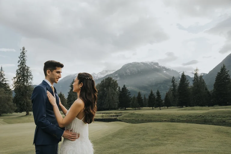 Wedding couple posing beside a mountain landscape